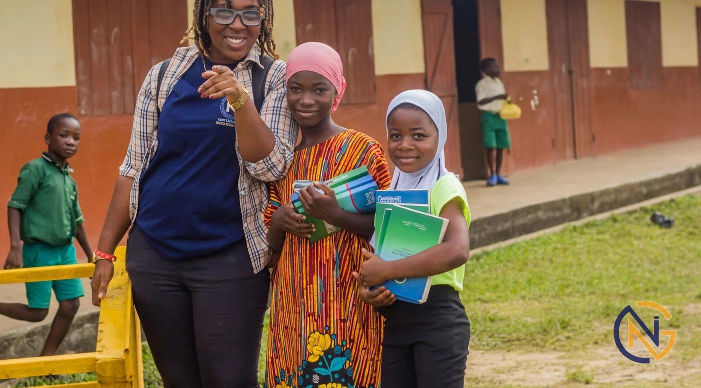 A mentor with two students holding school books